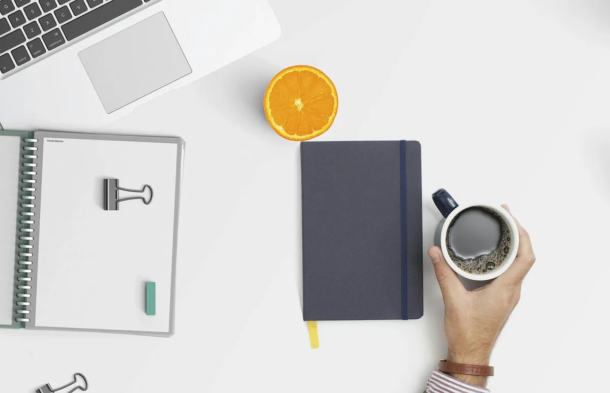 Carnet de budget et relevés bancaires sur une table illuminée par la lumière du jour