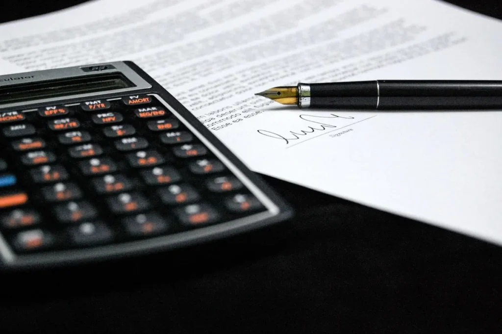 Bureau en journée avec dossier de liquidation et calculatrice sur un bureau en bois