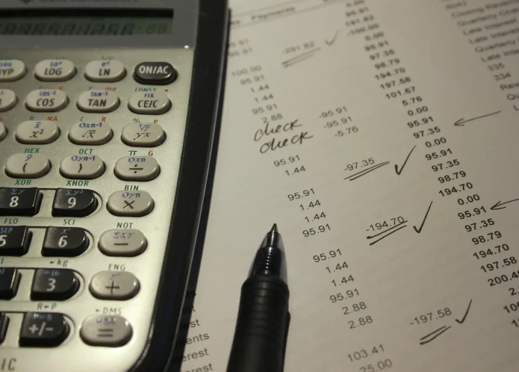 Bureau domestique avec documents de prêt et calculatrice posés sur une table