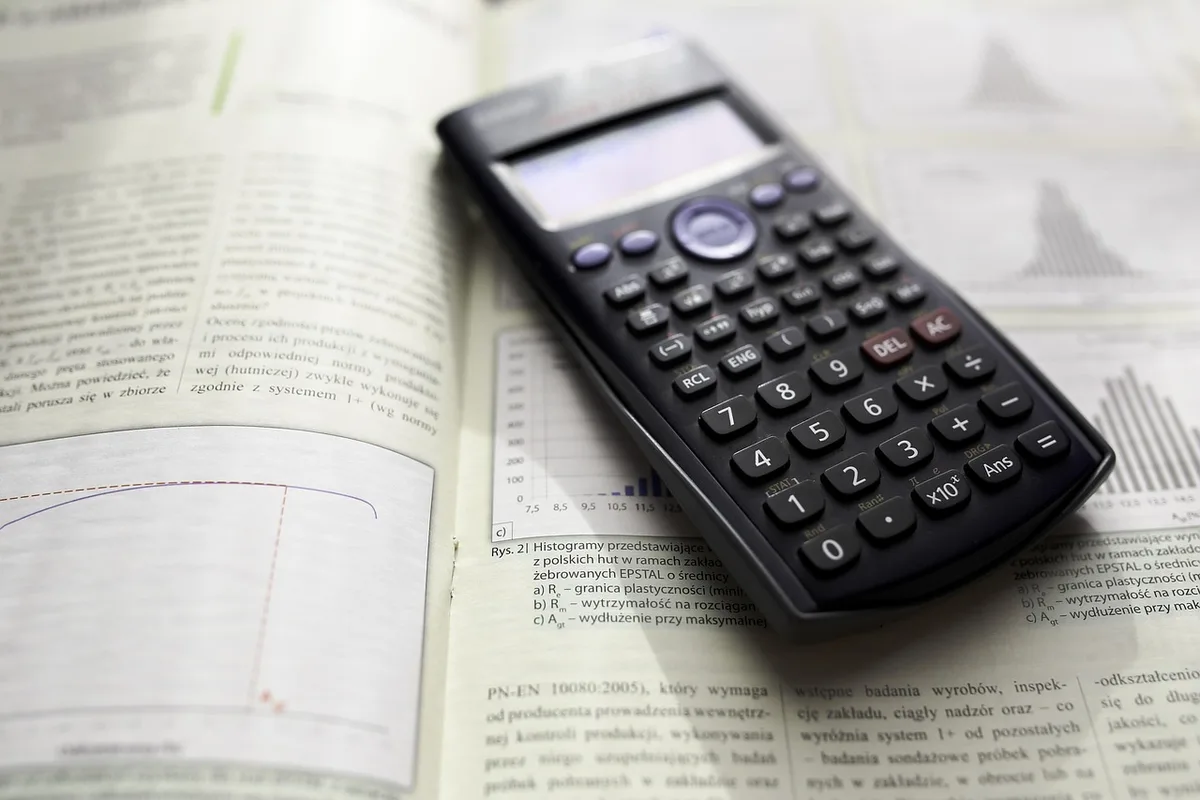 Calculatrice et feuilles montrant le calcul du taux d'endettement