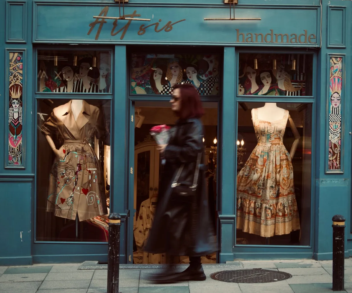 Façade de boutique de luxe en journée avec vitrines et passants flous