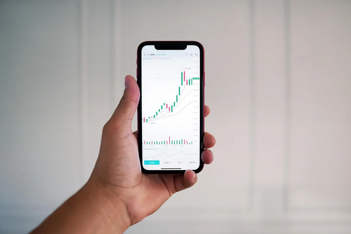 Portefeuille diversifié : documents, smartphone et étiquettes 'ETF' et actions