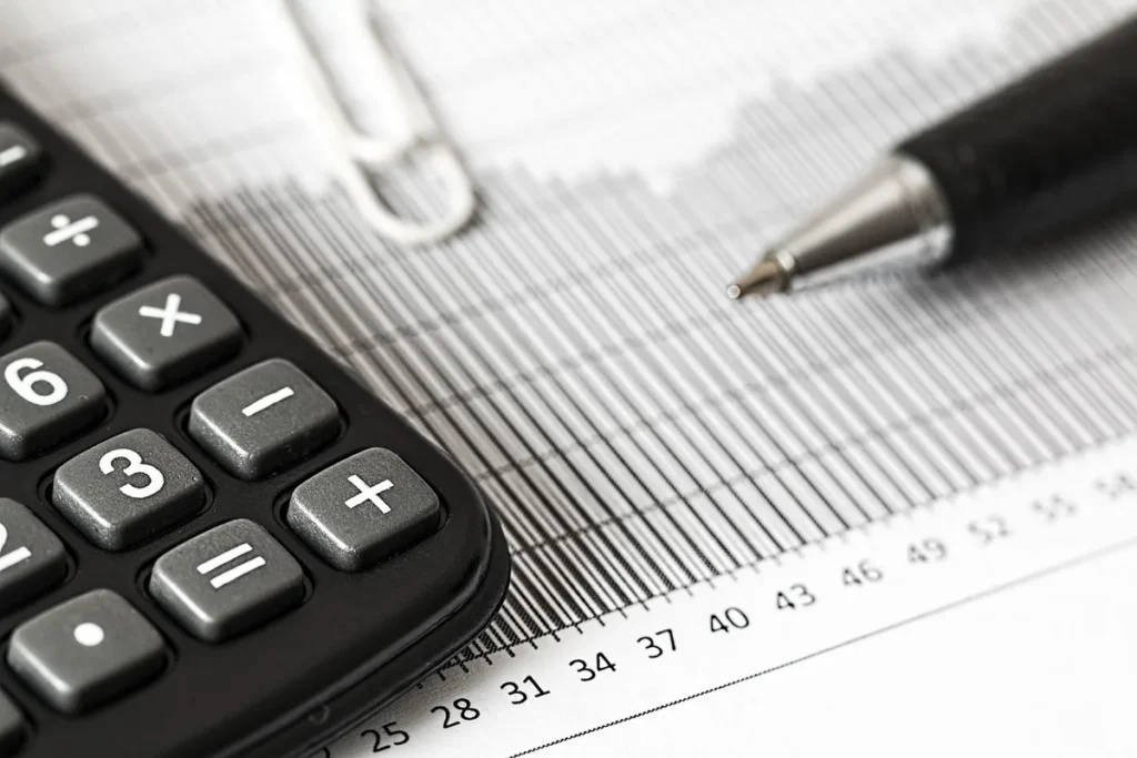 Bureau lumineux avec documents d'investissement, calculatrice et mains qui examinent des fiches