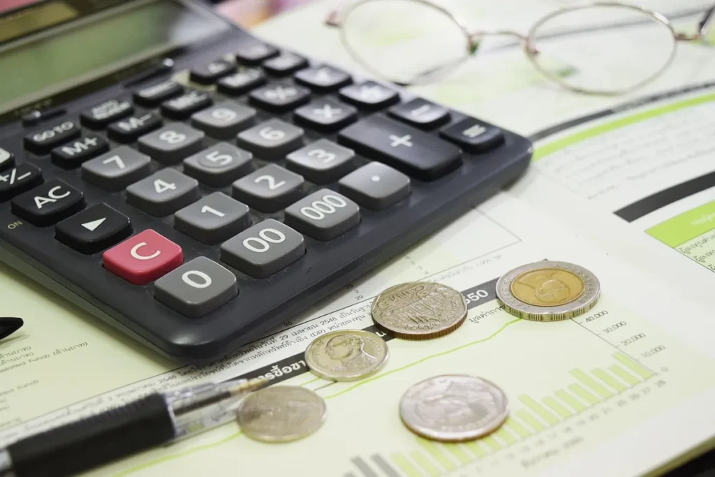 Carnet de budget, calculatrice et tirelire sur une table symbolisant la planification d'un placement
