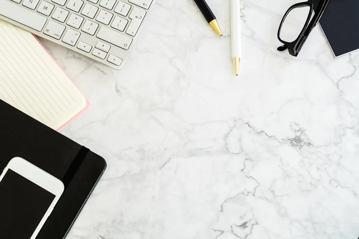 Bureau en journée, main tenant un stylo au-dessus d'un devis sur une table