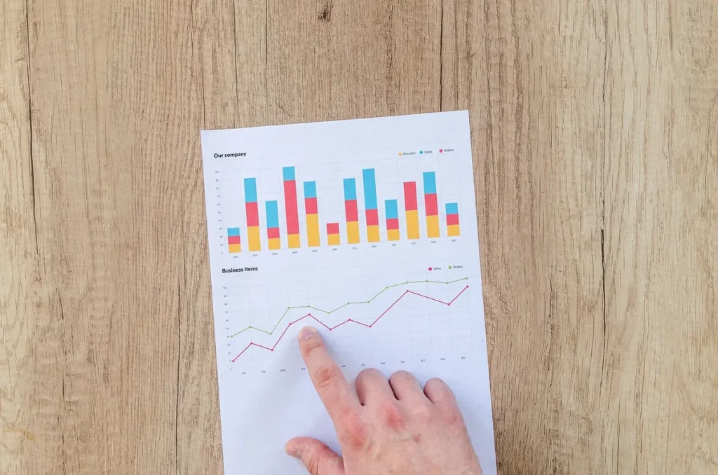 Bureau en pleine journée avec rapports financiers et graphique, mains lisant les documents