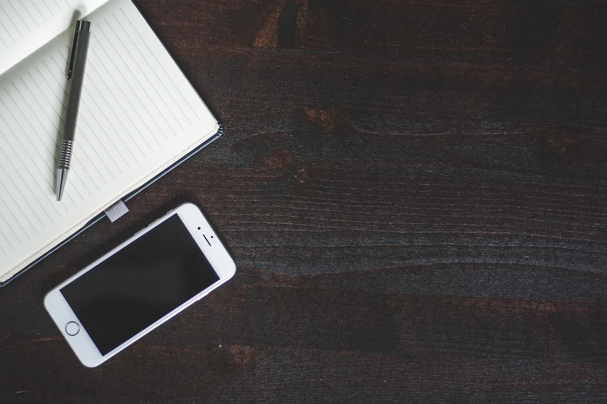 Personne appelant l'assistance voyage depuis un téléphone près de documents