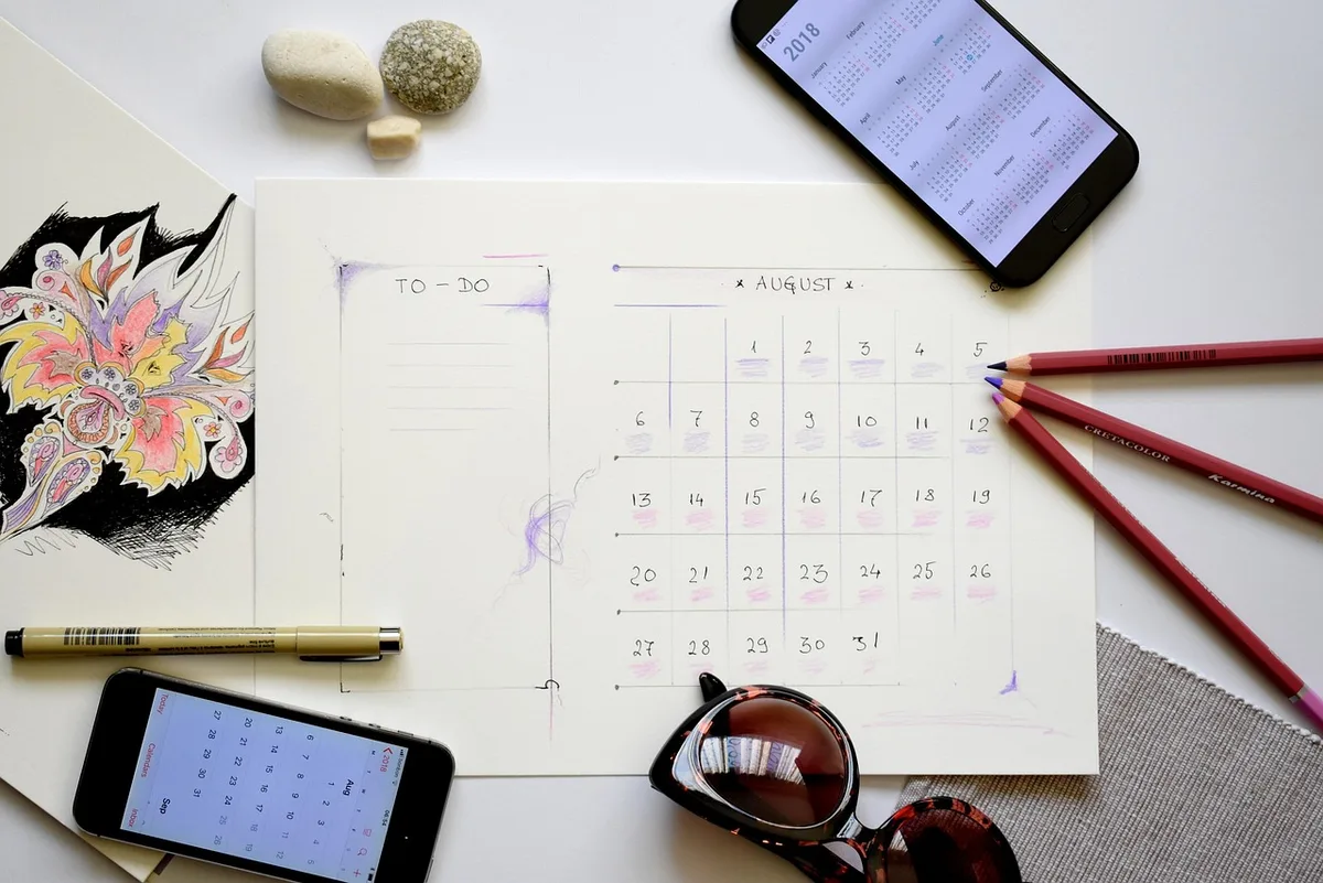 Calendrier des épreuves posé sur un bureau avec stylos