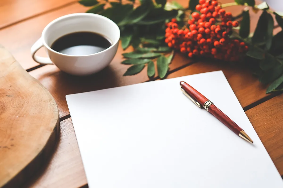 Carnet et stylo près d'une tasse pendant une séance de coaching, symbolisant l'écoute active