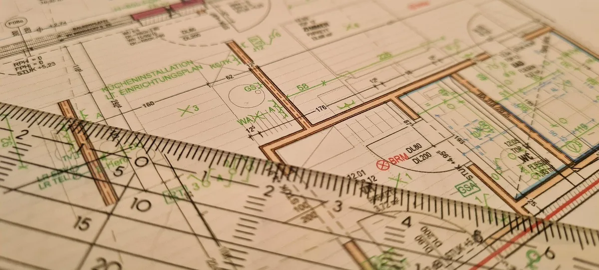 Main dessinant un plan d'aménagement intérieur sur une table claire