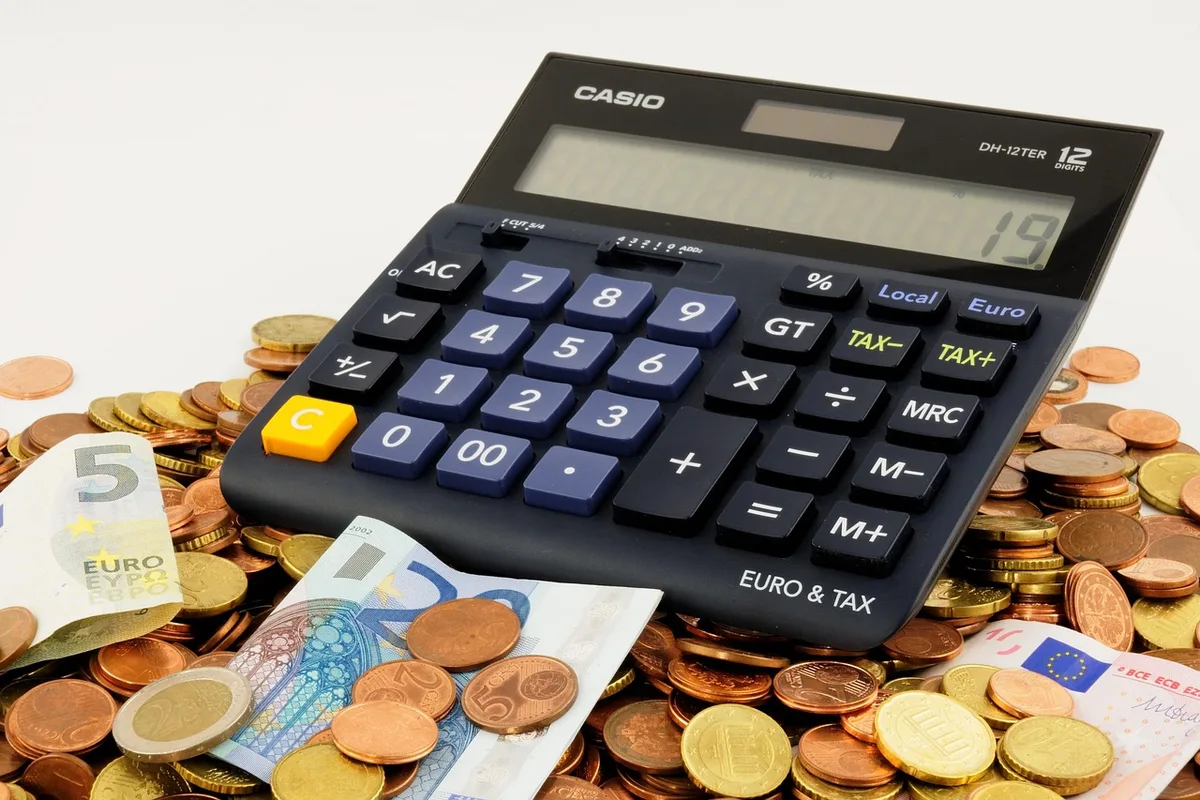 Jeunes gérant un budget sur une table avec calculatrice et carnet de comptes