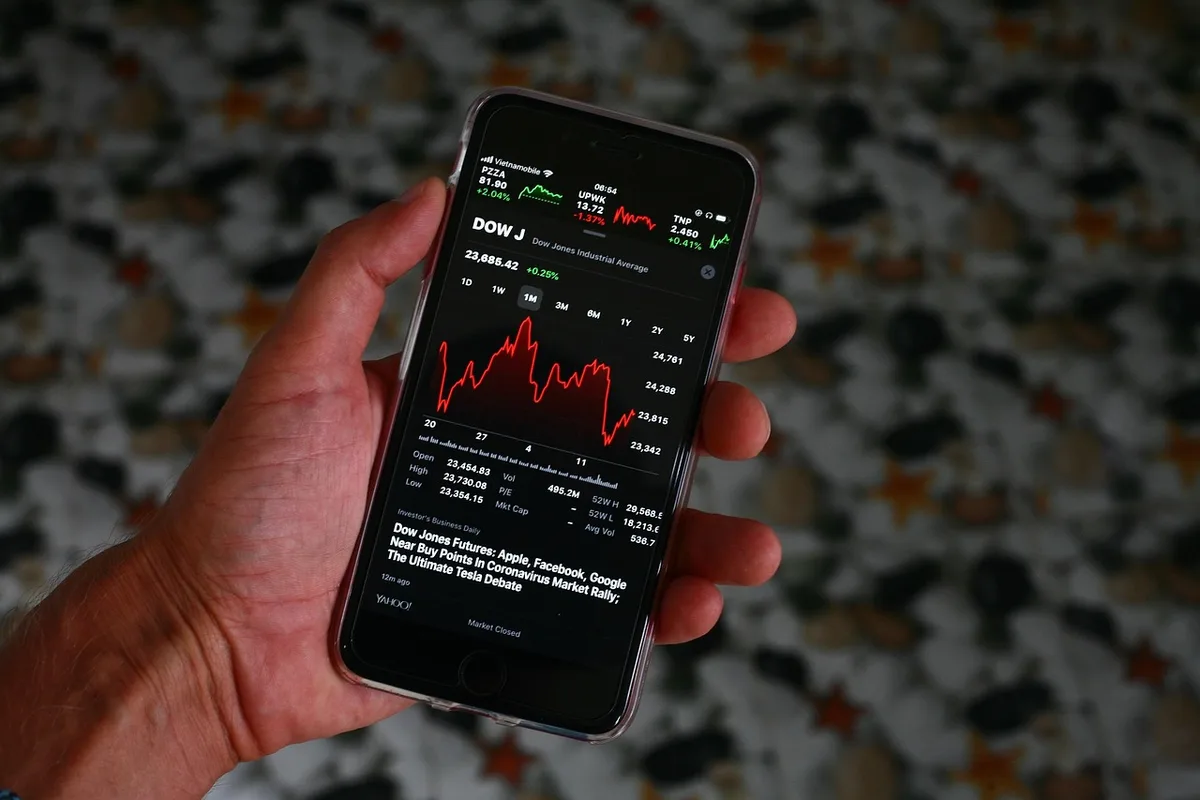 Écran d'application de trading montrant une action Veolia sur fond de bureau lumineux