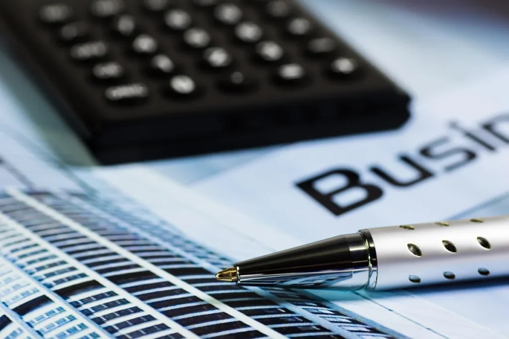 Main sur un relevé et une calculatrice sur un bureau en plein jour