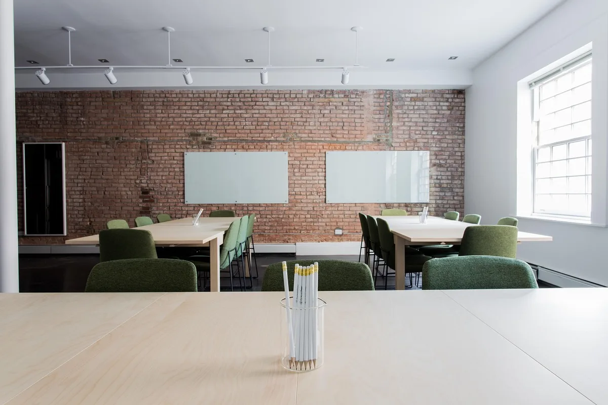 Jeune apprenant en formation pratique dans une entreprise, mains au clavier et documents