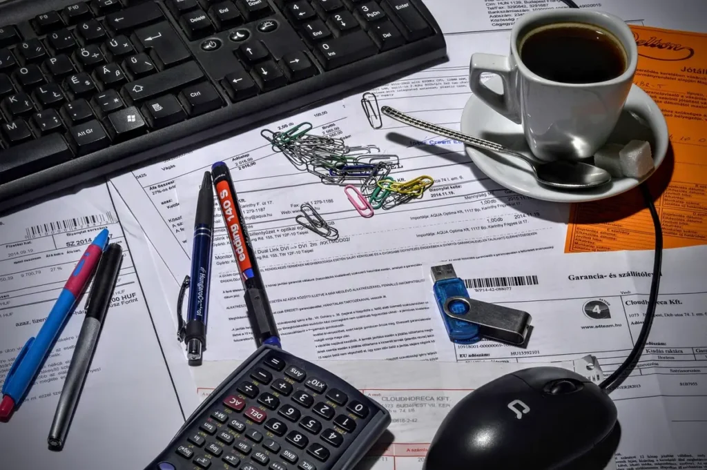 Locataire triant des documents et utilisant une calculatrice sur une table de cuisine en plein jour